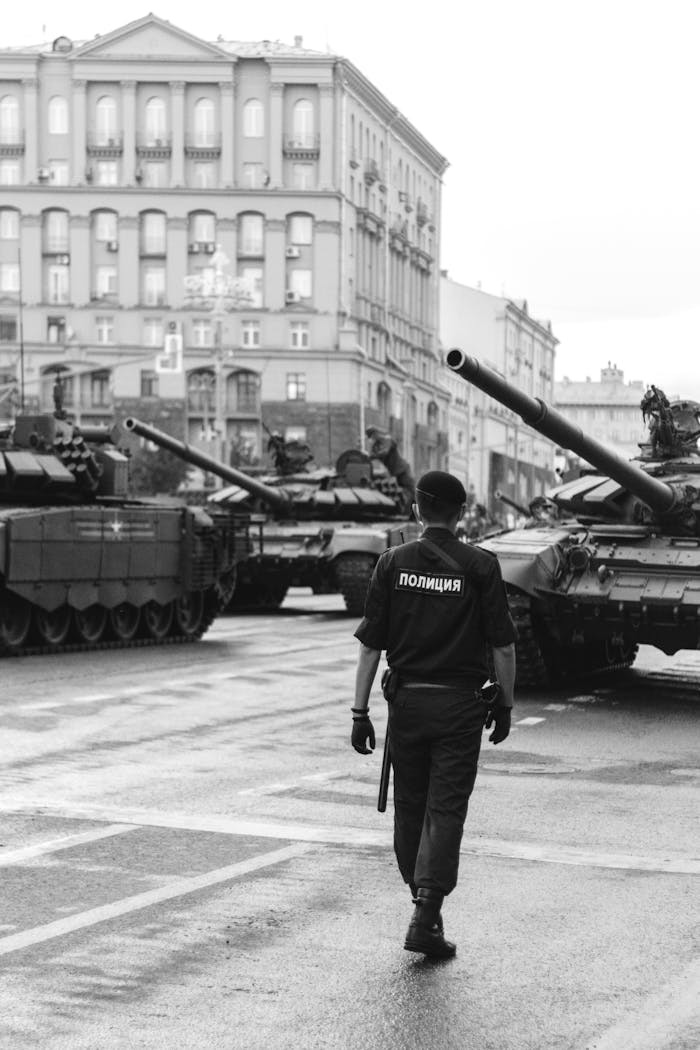 Policeman walking near Tanks
